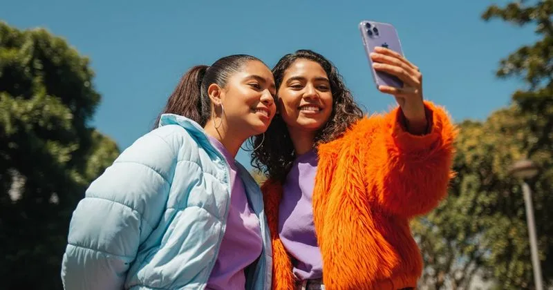 Pessoa gravando um vídeo com o celular no tripé
